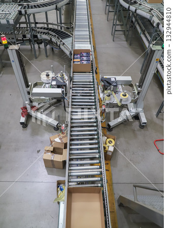 packing line in a logistics warehouse. conveyor belt in a modern production line packing line in a logistics warehouse. conveyor belt in a modern production line 132944810