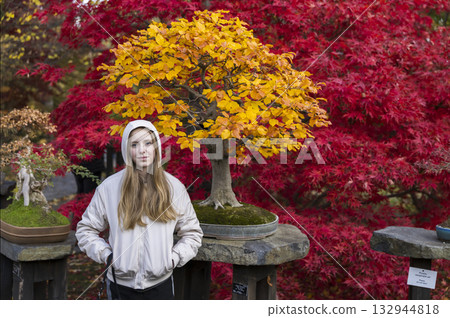 Young woman enjoying autumn colors in Prague bonsai garden 132944818
