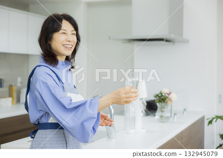 一個女人在廚房喝水 一個女人在廚房喝水 132945079