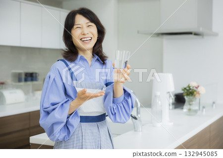 一個女人在廚房喝水 132945085