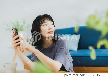 A young woman operating a smartphone 132945183