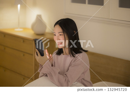 A woman watching a smartphone in bed A woman watching a smartphone in bed 132945720