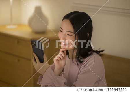 A woman watching a smartphone in bed 132945721