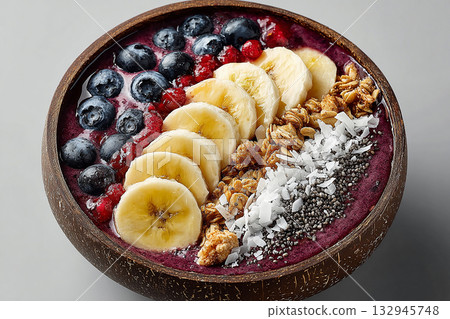 Smoothie bowl. Colorful acai bowl with banana slices, coconut flakes and granola on a white background.  Healthy and Wellness Breakfast for luxury resorts. 132945748