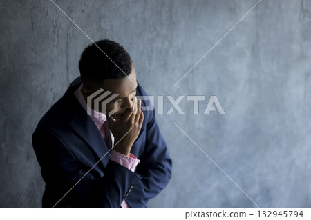 A foreign man wearing a suit and thinking 132945794