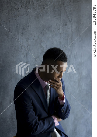 A foreign man wearing a suit and thinking A foreign man wearing a suit and thinking 132945795