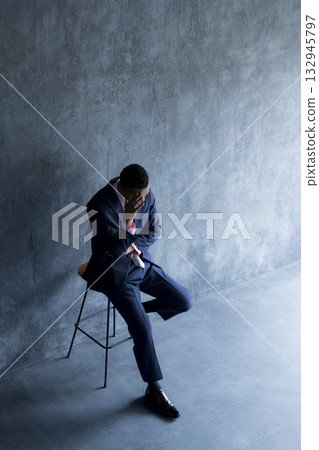 A foreign man wearing a suit and thinking 132945797