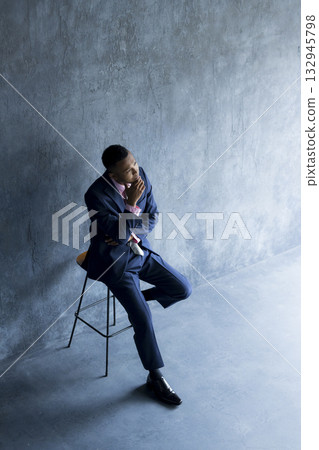 A foreign man wearing a suit and thinking 132945798