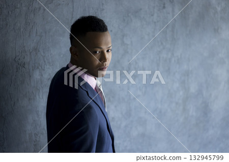 A foreign man wearing a suit and thinking 132945799