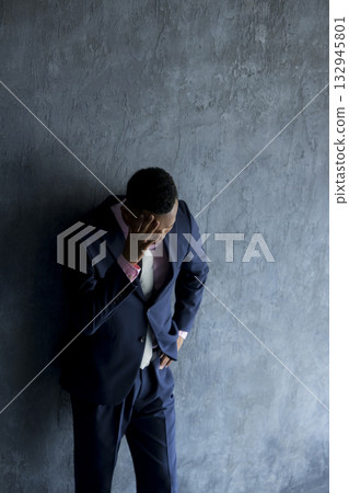 A foreign man wearing a suit and thinking A foreign man wearing a suit and thinking 132945801