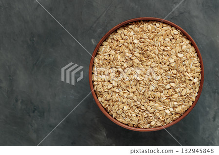 Uncooked Oat Flakes in Rustic Ceramic Bowl Flat Lay Copy Space 132945848