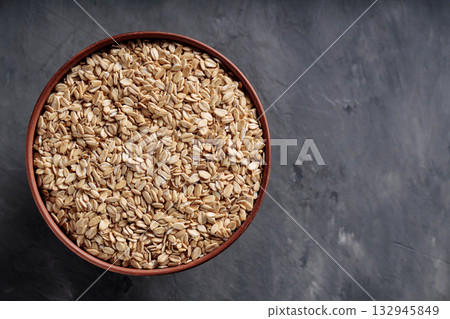 Uncooked Oat Flakes in Rustic Ceramic Bowl Flat Lay Copy Space 132945849