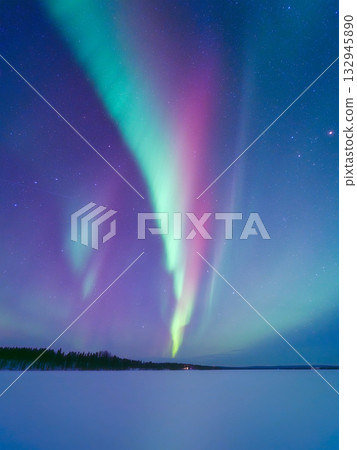 Aurora Borealis in Scandinavia. Northern lights over frozen lake. Starry sky. Glow on the sky. 132945890