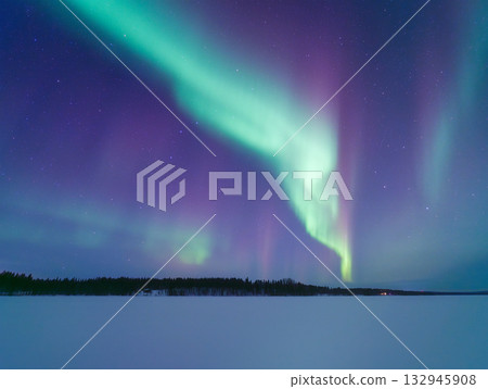Aurora Borealis in Scandinavia. Northern lights over frozen lake. Starry sky. Glow on the sky.  132945908