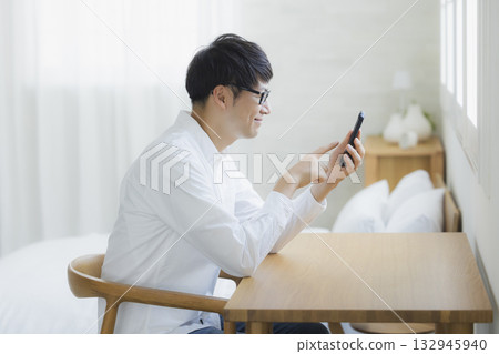 男人在臥室看智慧型手機 132945940