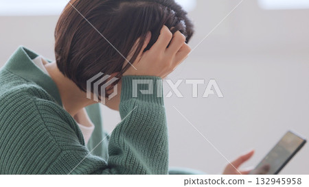 A woman watching a smartphone A woman watching a smartphone 132945958