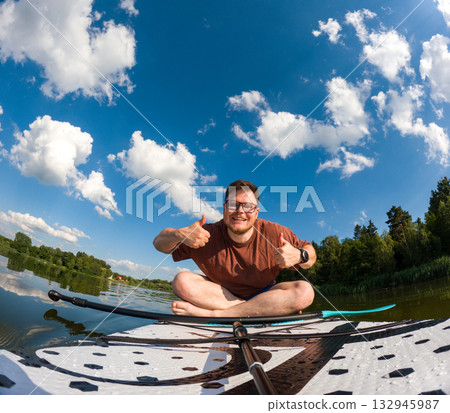 Man Taking Selfie on Paddleboard in Scenic Lake Man Taking Selfie on Paddleboard in Scenic Lake 132945987