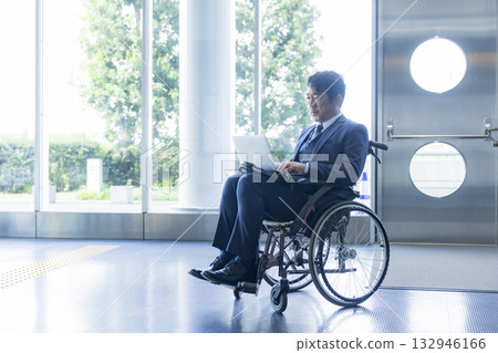 一名身穿西裝的男子坐在輪椅上 132946166