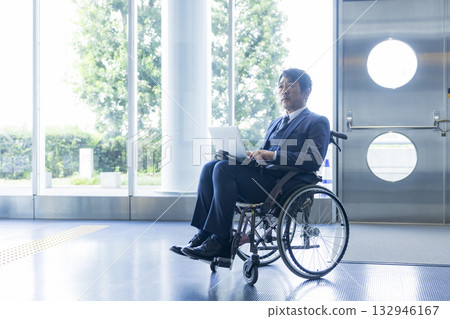 A man in a suit sitting in a wheelchair 132946167