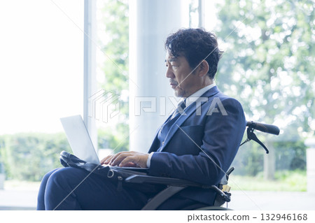 A man in a suit sitting in a wheelchair A man in a suit sitting in a wheelchair 132946168