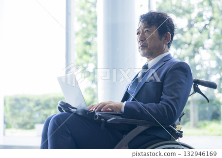 A man in a suit sitting in a wheelchair A man in a suit sitting in a wheelchair 132946169