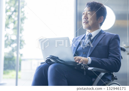 一名身穿西裝的男子坐在輪椅上 132946171