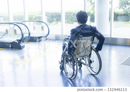 一名身穿西裝的男子坐在輪椅上 132946213