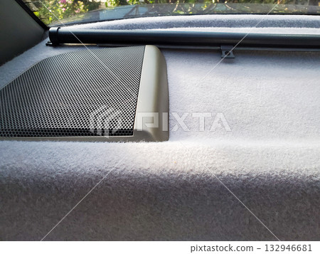 Close-up view of vintage car interior, soft grey upholstery showing rear shelf with built-in left speaker covered by perforated metal grille. For automotive design concepts, retro transportation theme Close-up view of vintage car interior, soft grey upholstery showing rear shelf with built-in left speaker covered by perforated metal grille. For automotive design concepts, retro transportation theme 132946681