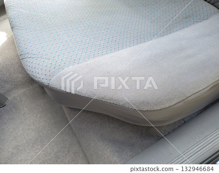 Close-up of rear seat in 1990s sedan, featuring soft grey upholstery with subtle blue dotted fabric pattern. The interior design typical of vintage cars, illustrating automotive retro interiors 90s Close-up of rear seat in 1990s sedan, featuring soft grey upholstery with subtle blue dotted fabric pattern. The interior design typical of vintage cars, illustrating automotive retro interiors 90s 132946684