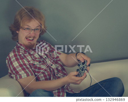 Gamer man playing using gaming pad 132946869