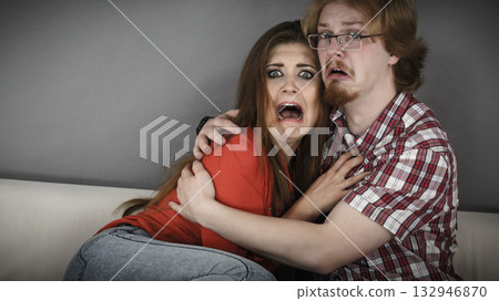 Funny couple watching horror movie Funny couple watching horror movie 132946870