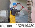 Adult worker demolish old house 132946880