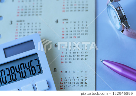 A calendar, a watch, and a calculator on the table A calendar, a watch, and a calculator on the table 132946899