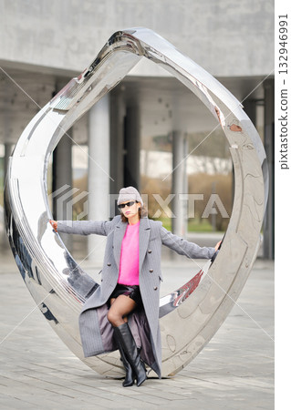 Urban street style shines through a modern sculpture in a city park on a bright day Urban street style shines through a modern sculpture in a city park on a bright day 132946991