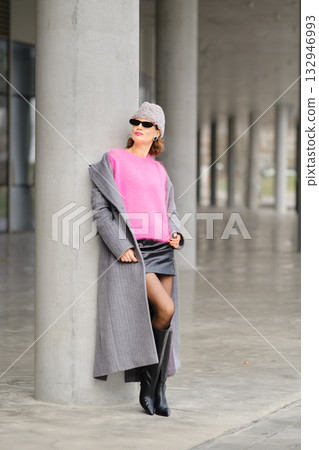 Urban street style with bold colors and modern fashion by a concrete pillar in an urban setting Urban street style with bold colors and modern fashion by a concrete pillar in an urban setting 132946993