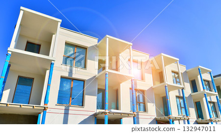 New multistory modern apartment buildings under construction in sunny day. New multistory modern apartment buildings under construction in sunny day. 132947011