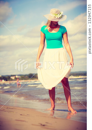 Blonde woman wearing dress walking on beach 132947155