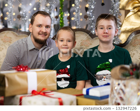 Happy father with children celebrating Christmas and giving each other gifts Happy father with children celebrating Christmas and giving each other gifts 132947226