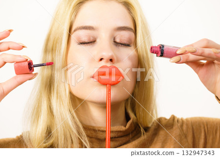 Woman applying lipstick or lip gloss 132947343