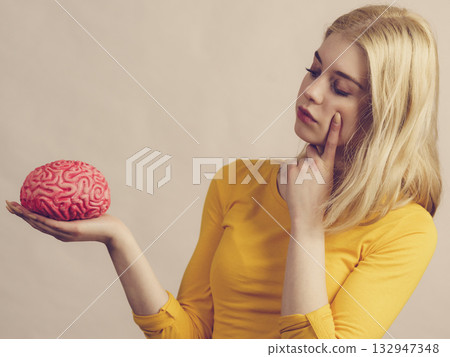 Woman thinking holds brain 132947348