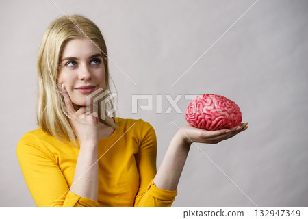 Woman thinking holds brain 132947349