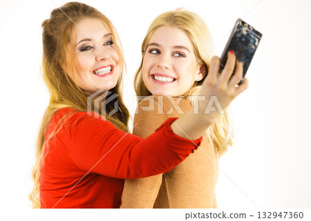 Two women taking selfie using smartphone Two women taking selfie using smartphone 132947360
