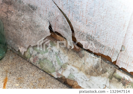 Close-up view of peeling wallpaper revealing damaged wall underneath, showcasing textures and colors, highlighting wear and tear in an indoor environment with natural light Close-up view of peeling wallpaper revealing damaged wall underneath, showcasing textures and colors, highlighting wear and tear in an indoor environment with natural light 132947514