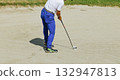 Golfer taking a shot in a bunker 132947813