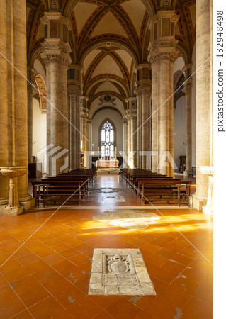 Pienza cathedral nave with rows of pews leading to altar 132948498