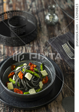 Squid ink pasta with asparagus and sun dried tomatoes 132948623