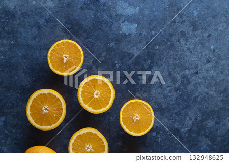 Fresh halved oranges on dark blue background 132948625