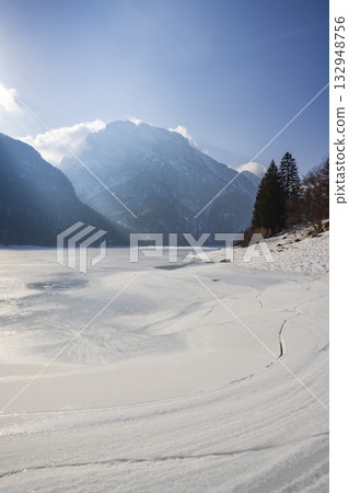 Frozen Lago del Predil with mountains surrounding it 132948756