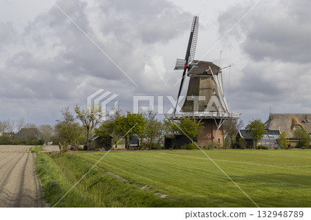 Dutch windmill standing in rural Friesland landscape, Netherlands 132948789