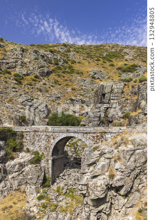 Historic stone bridge spanning mountain pass in Avila Historic stone bridge spanning mountain pass in Avila 132948805
